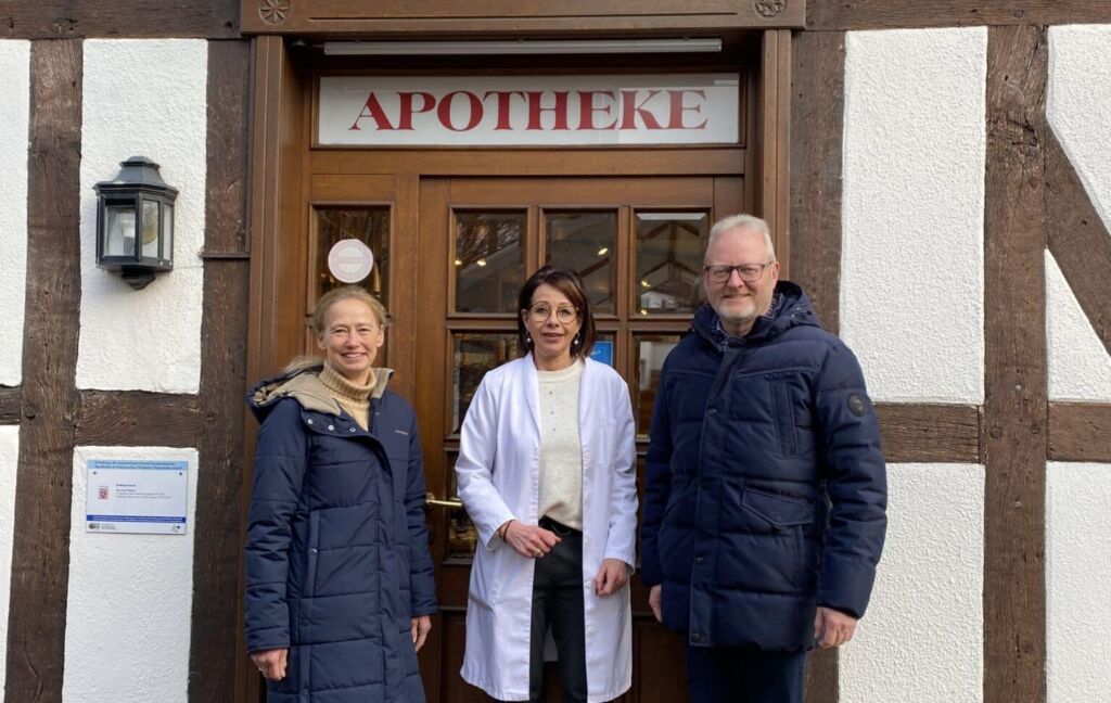 Jutta Birkenhauer, PORT Versorgungslotsin, Aptoheken Mitarbeiterin Bettina Zeuse-Schwarz und Bürgermeister Volker Becker stehen vor der Apotheke Adorf. 